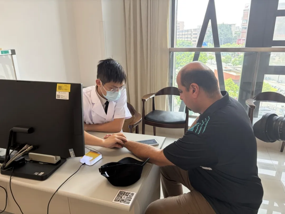 Physician taking pulse for a South Pacific delegate in TCM consultation room