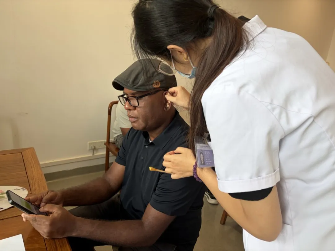 Nurse performing ear-point therapy on a delegate