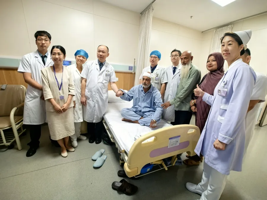 Bangladeshi patient Mr. Zakir gives a thumbs-up with the Foshan Chancheng Hospital skull-base MDT team