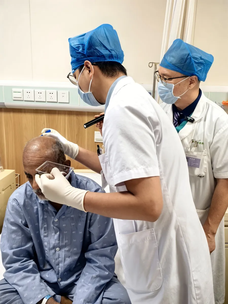 Surgeons examine Mr. Zakir’s postoperative incision during rounds