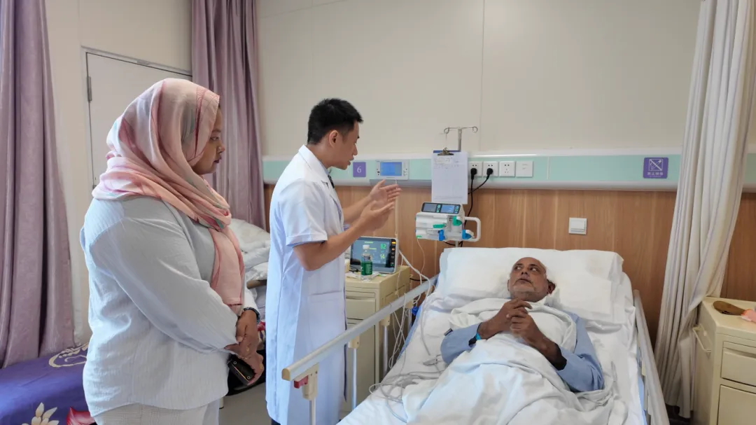 A Foshan Chancheng Hospital doctor speaks with Mr. Zakir’s family member at bedside