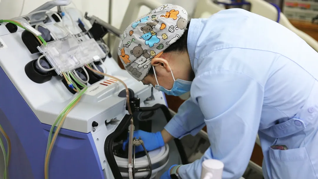 A nurse operates the apheresis machine during T-cell collection