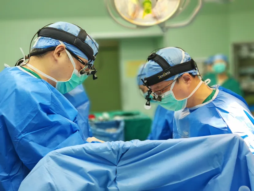 Surgical team performing a minimally invasive cardiac procedure wearing surgical loupes and headlamps